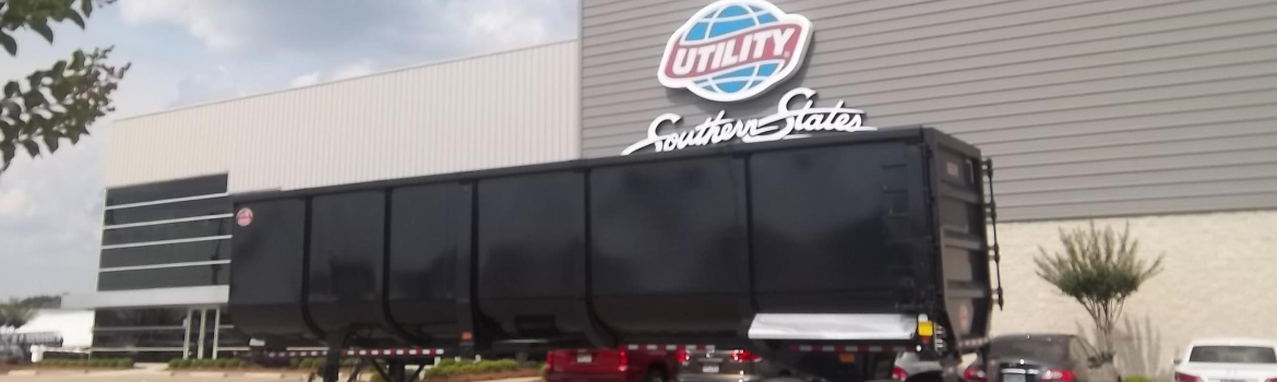 2019 Construction Trailer Specialists Scrap Master parked in front of cars and a building